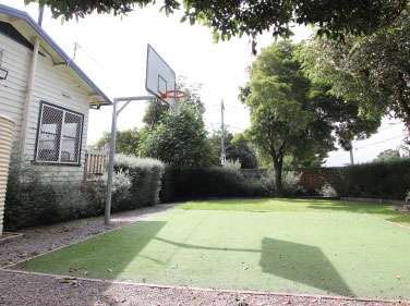 A garden area with a basketball hoop and garden beds.