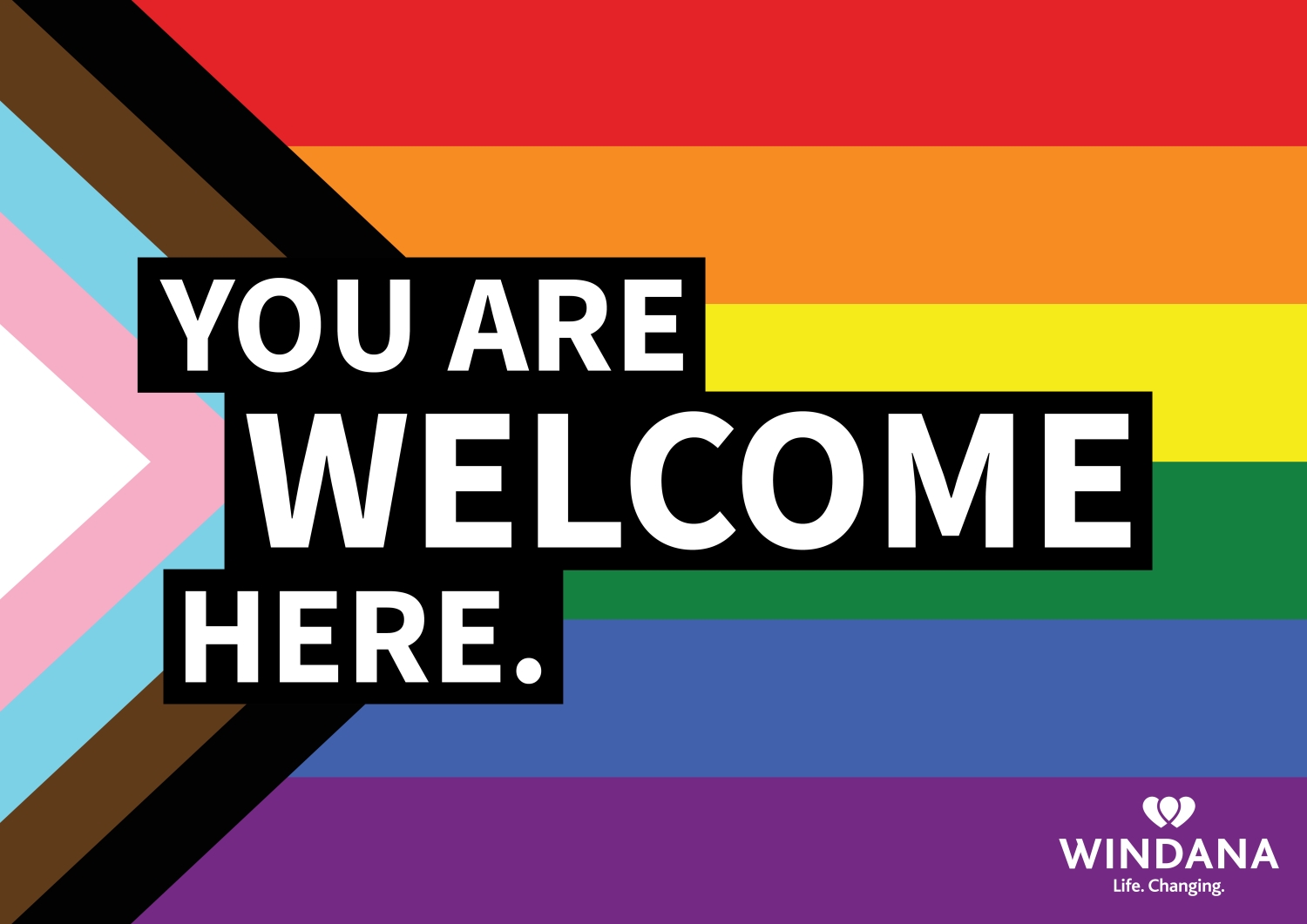 An image of the Progress Pride flag, made up of many colours. Text on the front reads "YOU ARE WELCOME HERE."